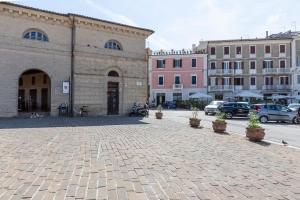 a street with buildings and potted plants on a street at La Romantica camere e wellness in Senigallia +22 photos