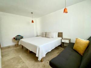 a bedroom with a white bed and a couch at Depto 2 Pisos, Vista Alberca. A 50 mts Del Mar in Nuevo Vallarta  +36 photos