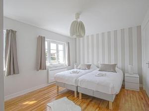 una camera bianca con un letto e una finestra di Holiday Home in the heart of Calvados with Terrace a Isigny-sur-Mer