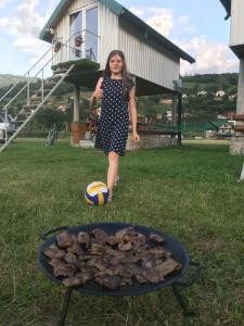 a girl standing next to a grill with a ball at Begov kamp, Plav in Plav