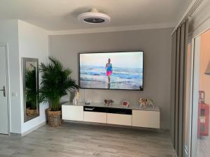 un soggiorno con TV a schermo piatto a parete di Magnífico apartamento vistas increíbles al océano-Caletillas-Candelaria ad Araya
