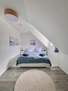 a white bedroom with a bed and a rug at Ferienwohnung LOUISE in Dreschvitz