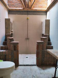 a bathroom with a toilet and a bunch of bricks at Paraíso de Mercedes in Pereira