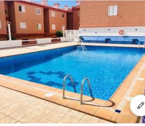 a large blue swimming pool in a building at Magnífico apartamento vistas increíbles al océano-Caletillas-Candelaria in Araya