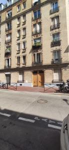 a large building with a brown door on a city street at *Street Clichy Art* - Appartement à 200 m de Paris ! in Clichy