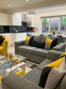 a living room with two couches and a kitchen at Corbridge Road in Reading