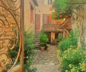 a stone path leading to a building with flowers at L'authentique Martelaise PISCINE CHAUFFEE in Martel