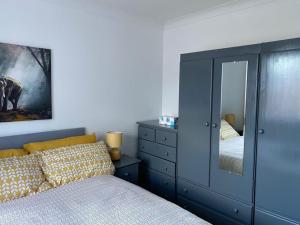 a bedroom with a bed and a dresser with a mirror at Beautiful 2-bedroom in Grays close to Lakeside in Grays Thurrock