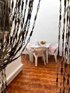 een eetkamer met een witte tafel en stoelen bij Casa Rotulì in Parabita