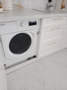 uma cozinha branca com uma máquina de lavar louça no balcão em Apartament Glamour Chełm em Chelm