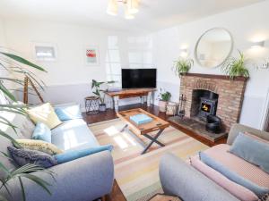 a living room with a couch and a fireplace at Rose Cottage in Louth