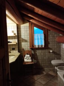 a bathroom with a sink and a toilet and a window at ROSINA HOUSE e CHALET in Colico