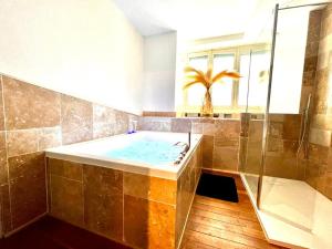 a large bathroom with a tub and a shower at Love Room Secrète Les Petits Plaisirs in Angers