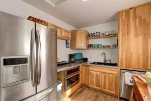 cocina con armarios de madera y nevera de acero inoxidable en Cozy Guesthouse with view from large deck, en Prescott