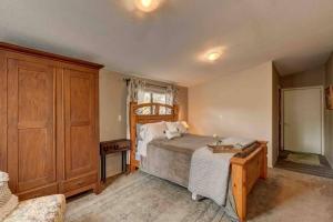 1 dormitorio con 1 cama y armario de madera en Cozy Guesthouse with view from large deck en Prescott
