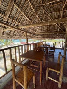 uma área de refeições com mesas e cadeiras sob um telhado em Mambo Boutique Nungwi em Nungwi