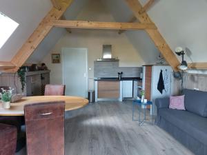 een woonkamer met een tafel en een bank bij Bed en Boomgaard in Giethoorn