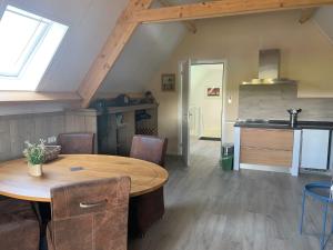 a kitchen and dining room with a wooden table in a room at Bed en Boomgaard in Giethoorn