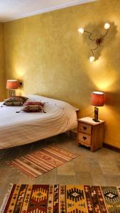a bedroom with a bed and a table with two lamps at Le Renard d'Introd in Introd