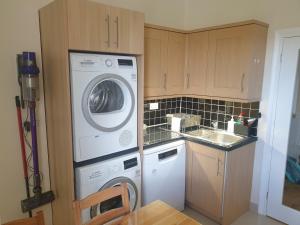 a kitchen with a washing machine and a sink at London Luxury 2 Bedroom Apartment 5 min from tube station with free parking in Wanstead