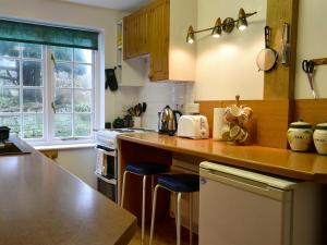 a kitchen with a counter with stools in it at White Rose Cottage in Robin Hood's Bay