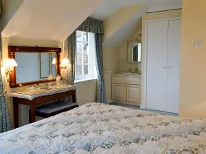 a bedroom with a bed and a sink and a mirror at White Rose Cottage in Robin Hood's Bay