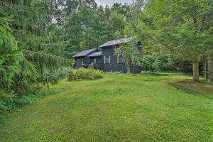 een zwart huis in het midden van een tuin bij Rustic Unadilla Cottage on 15 Acres with Pond! in Unadilla