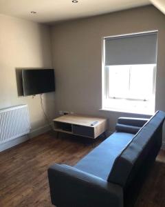 a living room with a couch and a flat screen tv at Mornington Harrogate in Harrogate