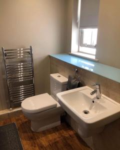a bathroom with a white toilet and a sink at Mornington Harrogate in Harrogate