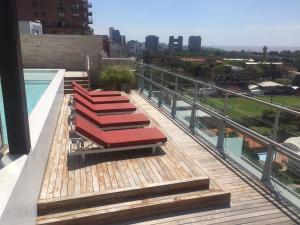 - un balcon avec une rangée de chaises rouges dans un bâtiment dans l'établissement Libertador Complete Suite, à Buenos Aires