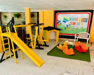 a childrens play area with a playground with a slide at Pousada Beira Mar in Pitimbu