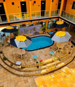 an overhead view of a swimming pool with umbrellas at Pousada Beira Mar in Pitimbu