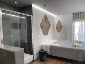 a bedroom with a bed and a shower and a tub at Pontinha Exclusive House in Faro