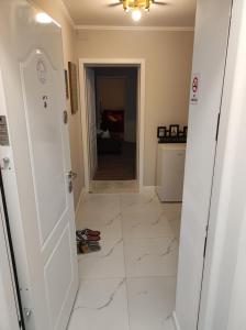 a hallway with a white tile floor and an open door at Scandinavian Home in Bucharest City Center in Bucharest