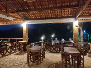 um restaurante com mesas e cadeiras num deque à noite em Chácara Bom Jesus em Caconde