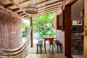 a patio with a table and chairs and a hammock at Vila Alta Caraíva in Caraíva +155 photos