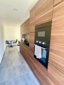 a kitchen with wooden cabinets and a stove at Pontinha Exclusive House in Faro