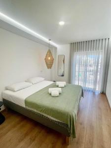 a bedroom with a large bed with two towels on it at Pontinha Exclusive House in Faro
