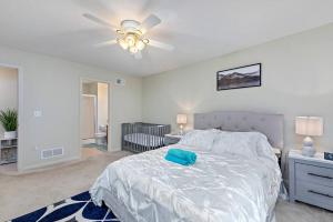 a bedroom with a white bed and a ceiling fan at Beautiful Townhome, 11 minutes to Downtown, KCMO. in Kansas City