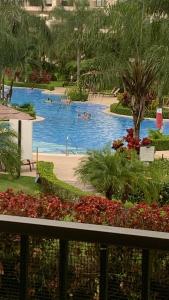 a pool in a resort with people swimming in it at JACO BAY in Jacó