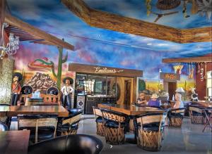 a restaurant with tables and chairs and a mural at Sonoran Sun Ground Floor - 104-W in Puerto Peñasco