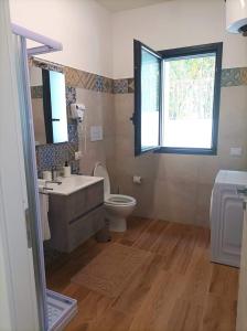 La salle de bains est pourvue d'un lavabo, de toilettes et d'une fenêtre. dans l'établissement Eraclea Minoa Apartments, à Eraclea Minoa