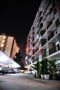 un gran edificio de apartamentos por la noche con coches aparcados fuera en Airport Resident, en Chiang Mai