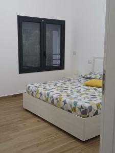 um quarto com uma cama num quarto com uma janela em Eraclea Minoa Apartments em Eraclea Minoa