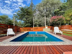 una piscina en una terraza con 2 sillas blancas en Casa Las Moras en San Antonio de Arredondo
