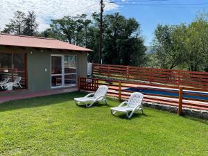 dos sillas sentadas en el césped junto a una casa en Casa Las Moras en San Antonio de Arredondo