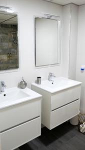 a white bathroom with two sinks and a mirror at Slappe Jaén I in Jaén