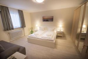 Un dormitorio con una cama blanca y dos lámparas. en Am-Sahlenburger-Strand-1-Whg-15, en Cuxhaven