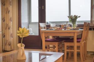 Un comedor con una mesa y un jarrón con una flor. en Am-Sahlenburger-Strand-1-Whg-15, en Cuxhaven