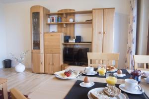 un comedor con una mesa con comida. en Am-Sahlenburger-Strand-1-Whg-15, en Cuxhaven 3 fotos más